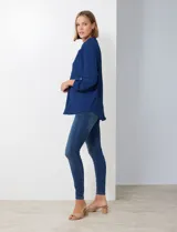 Blusa de gasa color beige, marca Floral & Ivy, con cuello a la base y escote en V. Las mangas son largas y regulables con presilla y botón.