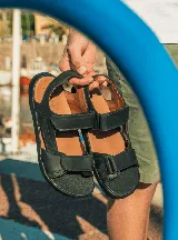 Sandalias negras de cuero con tiras ajustables con velcro.