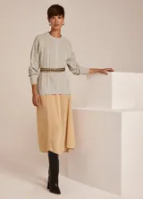 Sweater tejido en punto color gris claro, con cuello redondo y manga larga. Presenta diseño de trenzas en el frente y terminaciones acanaladas.