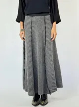 Pollera larga tejida de lana, color gris con rayas verticales en un tono más claro. Tiene cintura elástica y corte acampanado.