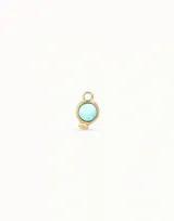 Dije de piercing dorado con forma circular y cristal celeste.