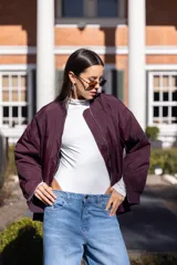 Body blanco de microfibra elastizada, con cuello alto y mangas largas. Cierre inferior con broches corseteros.