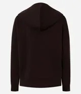 Buzo oversized de corte holgado, color negro, con capucha ajustable mediante lazos, mangas largas y puños elásticos.