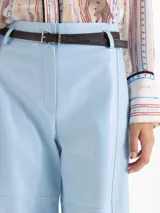 Pantalon de cuero ovino marron, de tiro alto, silueta wide-leg con recortes horizontales a la altura de la rodilla y bolsillos aplicados en la espalda. Incluye un cinturon de cuero al tono.