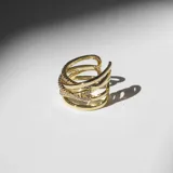 Anillo dorado con diseño entrelazado y cristales incrustados.