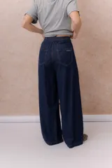 Jean de calce amplio y relajado, color azul, con pierna extra ancha y caída fluida. Diseño de tiro alto con pinzas delanteras y lazo regulable en la cintura. Cuenta con bolsillos laterales y traseros.
