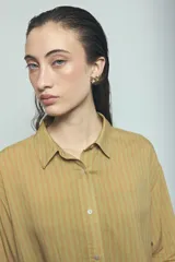 Camisa de viscosa con estampado de rayas verticales en tonos rosado y marrón, de corte oversize, con cuello camisero, cierre frontal de botones y mangas largas acampanadas.