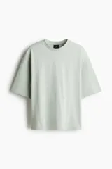 Remera de corte oversized en algodón pesado, con cuello redondo, hombros caídos y mangas cortas amplias.