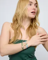 Pulsera de cuero verde con doble tira, dije central dorado con forma de ojo y cristal verde.