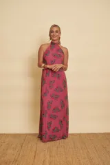 Vestido largo de gasa color fucsia, con estampado geométrico, escote halter y diseño fluido sin mangas.