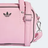 Bolso pequeño Adidas Adicolor XS de diseño estructurado en color rosado. Cuenta con doble asa superior, correa ajustable y desmontable para el hombro, cierre de cremallera y logo del trébol bordado en el frente.