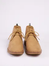 Botas tipo chukka color marrón, con cordones al tono, costuras reforzadas y suela de goma en color caramelo.