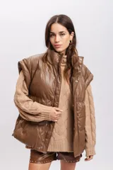 Chaleco puffer marrón de cuero sintético con cuello alto y cierre frontal con botones a presión.