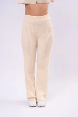 Pantalón tipo palazzo de tiro alto, confeccionado en tejido de punto acanalado color crema, con calce relajado y recto.