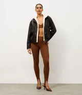 Legging deportiva de tiro alto confeccionada en microfibra elástica, con diseño ajustado y estribos en los pies. Presenta un acabado liso y una estructura que brinda soporte y libertad de movimiento.