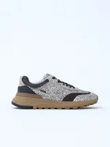 Championes urbanos de diseño exclusivo con paneles en cuero negro y textil estampado con motivo animal print de puntos. Presenta una suela de plataforma en tono marrón con relieve dentado y detalles en cuero beige en el talón.