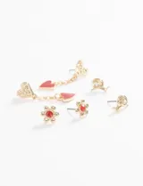 Set de tres pares de caravanas plateadas con diseños variados: un par con forma de caracol, un par con forma de flor con centro de cristal rojo y un par colgante con dije de corazón esmaltado en rojo.