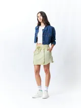 Minifalda color beige con elástico en la cintura, cordones ajustables y costuras marcadas en los laterales.