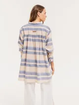 Camisa oversize con cuello mao, puño grueso y frunces en la espalda. Diseño a rayas horizontales azules y beige.