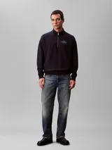 Buzo Calvin Klein azul marino de tejido terry, con cuello alto, cierre frontal parcial con cremallera, mangas largas, puños y ruedo acanalados. Cuenta con el logo de la marca bordado en el pecho.
