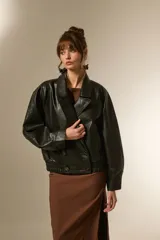 Campera estilo biker de eco-cuero color bordó, con cuello solapa ancho, manga larga y calce holgado. Presenta cierre frontal y botones decorativos en la parte inferior delantera.