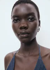 Top de estilo vaquero con escote en pico y espalda descubierta. Presenta un diseño evasé con fruncido elástico en la cintura y cierre mediante lazos en el cuello y el frente.