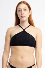 Top de bikini negro con estampado de hojas en relieve, modelo halter con tiras finas cruzadas en el cuello y espalda descubierta.