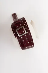 Cinto faja de cuero con estampado de vaca en blanco y negro, con hebilla metálica rectangular.