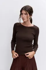 Pantalon de vestir color marron, de corte ancho y tiro alto, con diseño plisado y detalles de bolsillos frontales con botones.