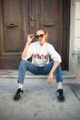 Buzo blanco de algodón con estampa roja en el frente con la palabra 'ch!c'.