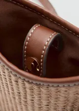 Bandolera porta celular Mango modelo Bilma, en color marrón y beige con textura trenzada, detalles en cuero sintético marrón, correa ajustable y desmontable, y cierre magnético.