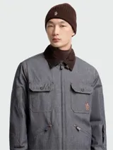 Gorro de lana tejido a punto acanalado, color marrón oscuro, con el logo de Moncler bordado en la parte frontal.