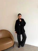 Pantalon de corte recto y holgado, confeccionado en lanilla con estampado de lunares blancos sobre fondo negro. Presenta cintura elástica para mayor comodidad.