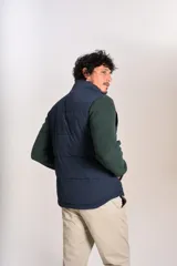 Chaleco tipo puffer color azul marino, con cierre frontal completo, cuello alto y logo bordado en el pecho.