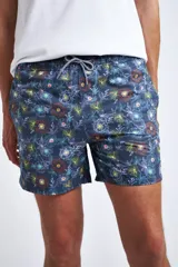 Short de baño con estampado de ondas en tonos azules, cintura elástica con cordón ajustable, bolsillos laterales y bolsillo trasero. Incluye suspensor interno y logo bordado.
