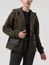 Campera de algodón color verde militar con capucha, cierre frontal con botones a presión y bolsillos delanteros con detalles de tejido aguayo multicolor. Presenta puños elásticos y cordón de ajuste en la capucha.