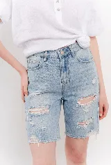 Bermuda de denim azul claro con efecto desgastado y roturas, de tiro medio y calce relajado.