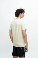 Remera de manga corta color verde agua con bolsillo en el pecho y estampado de un sol.