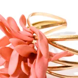 Brazalete dorado con diseño floral anaranjado.