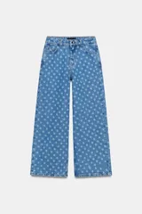 Jeans de tiro alto con pernera ancha, diseño cropped y estampado de lunares, con cinco bolsillos y cierre frontal de cremallera y botón metálico.