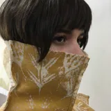 Cuello de lana merino afieltrada color crudo con estampado de líneas grises formando una cuadrícula.