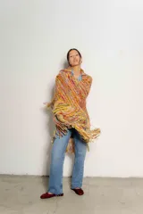 Chaleco tejido a crochet con flecos largos, diseño multicolor con predominancia de tonos tierra, naranja, amarillo y rosa.