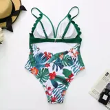 Malla enteriza con diseño combinado, parte superior en color verde petróleo con borde festoneado y parte inferior con estampado floral sobre fondo negro.