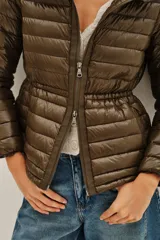 Campera puffer negra con capucha, cierre frontal con doble cremallera y diseño entallado en la cintura.