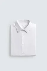 Camisa de corte slim fit confeccionada en tejido de algodón, con cuello italiano, manga larga con puños abotonados y cierre frontal de botones.