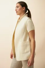 Chaleco color crema con solapas, corte entallado y bolsillos plaqué.