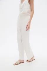 Pantalon de viscosa color blanco, de corte recto, con bolsillos laterales y cintura elástica con cordón ajustable.