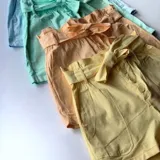 Short color amarillo pastel con cintura elastizada y detalle de botones frontales.