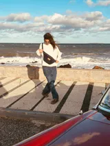 Riñonera de cuero con estampado animal print de vaca en blanco y negro, con correa regulable y cierre superior.