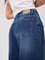 Jean de pierna ancha con tiro medio, confeccionado en denim de algodón con lavado clásico.